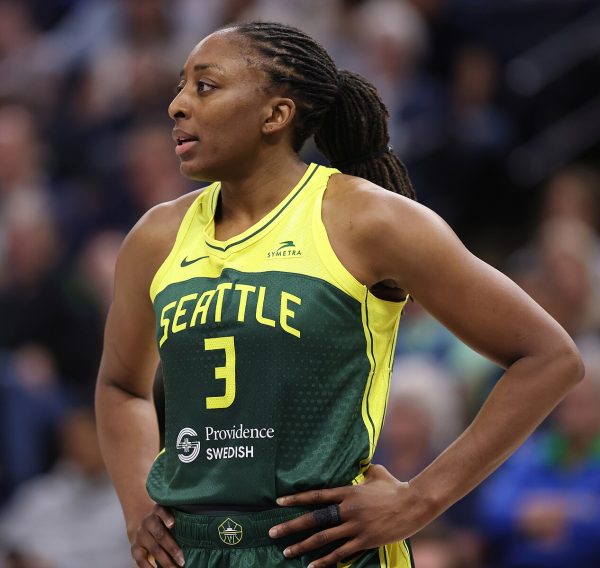 Nneka Ogwumike stands with her hands on her hips in a Seattle Storm uniform.
